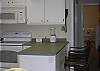 The open kitchen has a counter with two bar stool seating.