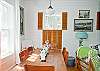 Dining area seats eight at heart-pine harvest table, adjacent to kitchen. There is an antique wicker high-chair for our youngest guests.