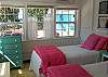 Bedroom 3 features 2 twin beds. The back windows look out to the back yard and patio with seating.