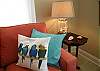 These parrot pillows are on the sofa in the living room area.