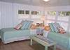 This bedroom area features two twin beds and cable TV. This is also the back area of the cottage and has the washer and dryer in this area and the back door.