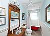 This bathroom features a old fashioned claw footed bathtub/shower combination.