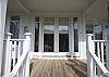 The floor to ceiling front doors lets in wonderful natural lighting.  The deck on this level wraps around the entire first floor. To the righ of the front door is the  picnic table  which seats 8 and to the left is the  gas grill.