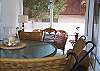 The back screened porch has table seating as well as wicker chairs and sofa seating.