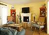 The living room is on the first floor and features a fireplace and a flat screen large tv over the fireplace.