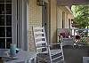 The front screened porch features rocking chairs and a view of 7th Street.