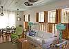 Comfy sofa and vintage rattan seating area arranged to view 42-inch flat screen TV-DVD and stereo.