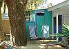 Another view of the outdoor deck with the oak tree, vintage beach chairs and the outdoor shower with hot and cold water.