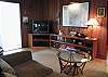 The living room features a large tv, books, games and a cd player. The large map is showes all of Tybee and surrounding areas