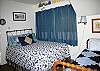 This bedroom features 1 queen bed and 1 twin bed. The bedroom has direct access to the family room and main hallway