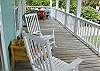The front of the home has a porch that stretches all the way across the front.  2 Rocking chairs, seating for six and hanging ferns and flowers to make the porch even more beautiful!