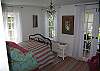 Bedroom 1 features a chandelier, marsh views from all windows, french doors leading out to the screened porch, Pine Cone Hill bedding and a wonderful bed to sleep!