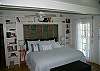 The king bed bedroom features a full bath, which also leads to the outside private shower with hot and cold water and fenced in garden and yard.  There is a HD TV with CD/ DVD player as well.  Book shelves are filled with books.
