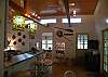 This picture showes the counter seating looking into the kitchen as well as the high ceilings and the large wall mounted TV.