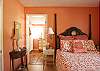 This master bedroom features a queen bed. The coral room and matching bathroom will surround you with the feeling of a warm beach flooded with warmth.