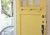 Nora's cheerful yellow front door beckoning you inside!