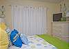 Another view of the light, bright and airy bedroom upstairs with queen bed and a private balcony. Note the flat-screen TV in the far corner.