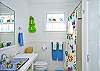 Full bathroom; located between Bedroom #2 and Bedroom #3 in hallway.  Bright, beachy and colorful!