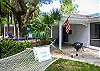 Side yard and deck under the oak tree at Sea Largo cottage.  Sea Largo Cottage has a hammock and a charcoal grill.