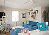 Large, open, bright family room with denim beach-friendly furniture &amp; flatscreen TV.  Fun chair swing!