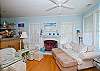 The cottage has a very open layout.  This is the large family room with cable TV and library, dining room and even the kitchen.  There is also a wood burning fireplace. Tall ceilings and lots of natural lighting.
