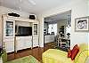 Upon entering the front door, you walk into the living room area. There is ample seating, a queen-size sofa bed, and an entertainment center with a flat screen TV. To the right, you see into the dining room and kitchen.