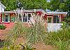 The front of the cottage is full of a beautiful garden area and seating.