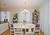 This view is the dining room looking toward the kitchen. Floor to ceiling windows allow a great amount of natural light to filter into the entire house.