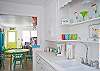 Views of the bright, cheerful kitchen which is on back of cottage through the living area.