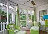 The screened porch is across the front of the cottage. Full of lime green wicker.