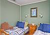 This bedroom has two twin beds as well as cable TV.