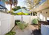 The back yard has seating and unbrella. This area connects to the private pool and has just the right amount of room for sunbathing in the private back yard if you need a break from the beach or for that late afternoon ice tea break!
