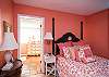 This master bedroom features a queen bed. The coral room and matching bathroom will surround you with the feeling of a warm beach flooded with warmth.