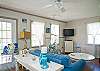 Large, open, bright family room with denim beach-friendly furniture &amp; flatscreen TV.