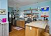 The kitchen is also part of this open floor plan. Fully equipped with a kitchen counter and bar stools in addition to the large family style dining room table.