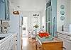 Our full equipped and stocked kitchen has everything you need to be creative with our coastal food treasures.  The seating area is part of the kitchen.  The blue shutters are from a local antique store repurposed as doors.