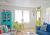 Views of the spacious, open living and dining area. Bright, colorful and fun! This area includes a bar with extra seating; fun place to sit and have a snack!