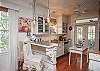 The fully stocked kitchen includes a kitchen counter with three bar stools. The counter was made of the orginal siding from the cottage. The counter top is metal.