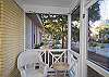 The front screened porch features rocking chairs and a view of 7th Street.