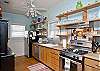 The kitchen is also part of this open floor plan. Fully equipped with a kitchen counter and bar stools in addition to the large family style dining room table.