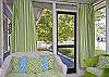 The screened porch is across the front of the cottage. Full of lime green wicker.