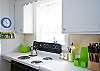 Views of the bright, cheerful kitchen which is on back of cottage through the living area.