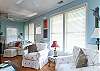 The cottage has a very open layout. This is the large family room with cable TV and library, dining room and even the kitchen. There is also a wood burning fireplace. Tall ceilings and lots of natural lighting.