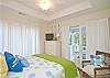 Another view of the light, bright and airy bedroom upstairs with queen bed and a private balcony. Note the flat-screen TV in the far corner.