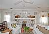 The great room is a combination of the living room, dining room and open kitchen. Hardwood floors everywhere. The fireplace is an electric fireplace. You walk in from the sunroom directly into the "great" room.  This is the center of the room with the slipcovered seating and the electric fireplace.