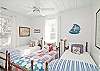 This bright and cheerful bedroom features 3 twin beds. The decor is vintage nautical with red, white and blue bedding, vintage treasures and lots of natural light. Great bedroom!
