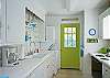 Views of the bright, cheerful kitchen which is on back of cottage through the living area.