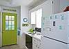 Views of the bright, cheerful kitchen which is on back of cottage through the living area.