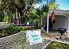 Side yard and deck under the oak tree at Sea Largo cottage.  Sea Largo Cottage has a hammock and a charcoal grill.