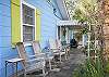 The side porch features rocking chairs and a view of the side garden. This cottage is right beside Nora's Cottage and directly across the street from Basking Under the Tybee Sun and Good Times Vacation Apartment. Makes this area ideal for several families to gather.